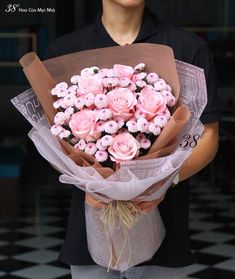 a man holding a bouquet of pink roses