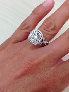 a woman's hand with a diamond ring on top of her finger and an engagement band