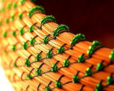 a close up view of a woven basket with green beads on the edges and sides