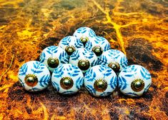 twelve blue and white ceramic ornaments sitting on a marble counter top, with gold accents