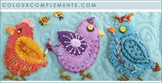 three colorful birds sitting on top of a blue blanket