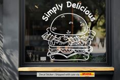 there is a window that says simply delicious with a drawing of a hamburger on it