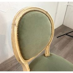 a green chair sitting in front of a mirror on top of a hard wood floor