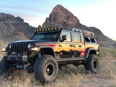 a jeep is parked in the grass near mountains