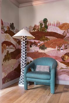 a blue chair sitting in front of a lamp on top of a hard wood floor