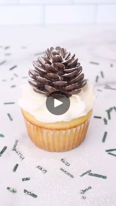 a cupcake with frosting and a pine cone on top