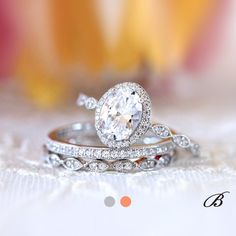 two wedding rings on top of each other with flowers in the backgrouf