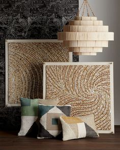 pillows and lamps are arranged on the floor in front of a wall with an intricate design