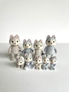 a group of small figurines sitting next to each other on a white surface