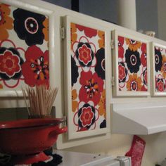 the kitchen cabinets are decorated with colorful flowers and vases in red, black, white and orange