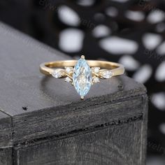 a gold ring with an aqua blue topazte and white diamond accents on it