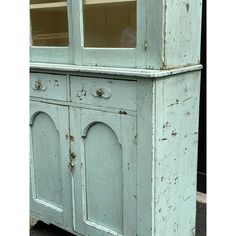 an old blue painted china cabinet with glass doors