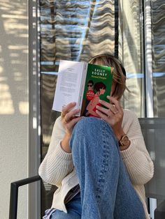 a woman sitting in a chair reading a book