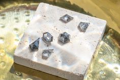 some diamonds are sitting on top of a piece of white soap that sits on a gold plate