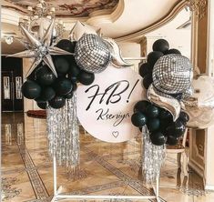 black and silver balloons are on display in front of a sign