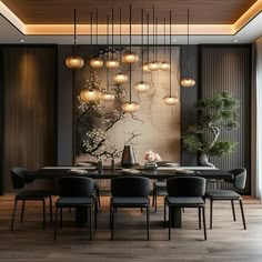 a dining room table with black chairs and lights hanging from the ceiling