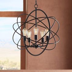 a chandelier with three lights hanging from it's center and an orb design