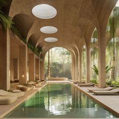 an indoor swimming pool with lounge chairs and palm trees