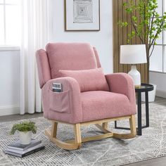 a pink rocking chair sitting on top of a rug