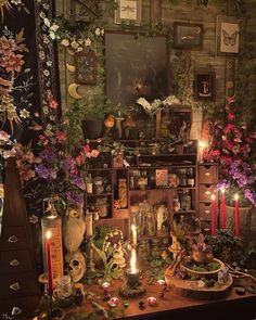 a table topped with lots of different types of flowers and candles on top of it