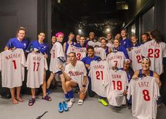 the women's baseball team is posing for a group photo in their locker room