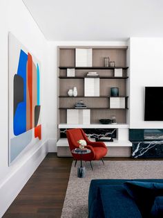 a living room filled with furniture and a flat screen tv on top of a wooden shelf