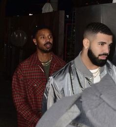 two men standing next to each other at night