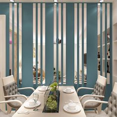 a dining room with blue walls and white chairs around a long table that has plates on it