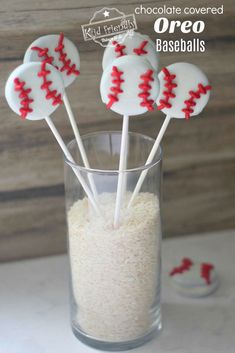 baseball cake pops in a glass filled with rice