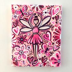 a pink and black painting with hearts and a fairy on it's back, sitting on a white surface