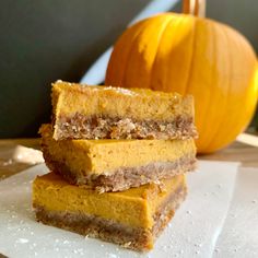 three pieces of cake sitting on top of a white paper towel next to a pumpkin