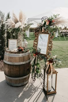 a wooden barrel with a sign on it next to a lantern and some candles in front of it