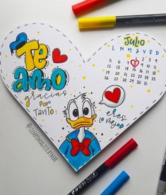 a heart shaped calendar with markers and crayons