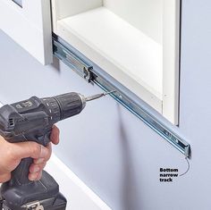 a person using a drill to fix a cabinet door