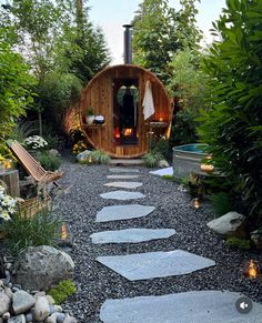 a garden area with stepping stones and a wood fired stove in the center, surrounded by greenery