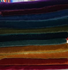 a pile of different colored velvets sitting on top of each other