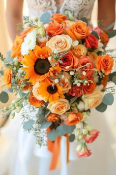 the bride is holding her orange and white bouquet