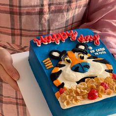 a person holding a cake in front of their face with the words happy birthday written on it