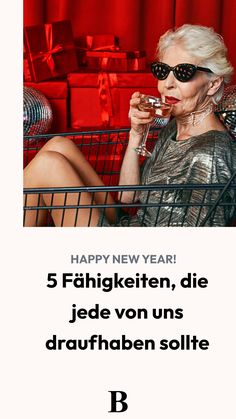 a woman sitting in a shopping cart holding a wine glass with the words happy new year