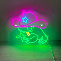 a neon sign with a frog wearing a cowboy hat