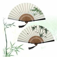 two white fans with bamboo leaves on them