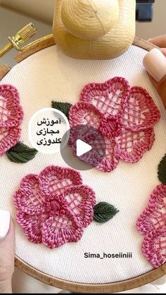 a person is stitching flowers on a piece of fabric