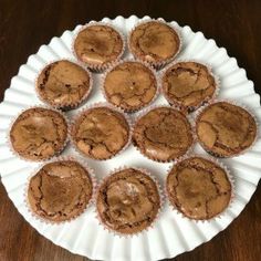 a white plate topped with chocolate cupcakes on top of a wooden table