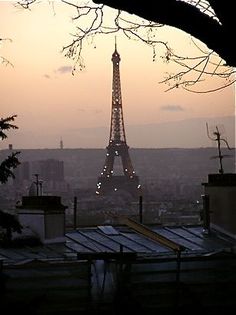 the eiffel tower is lit up at sunset