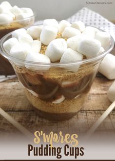 two bowls filled with marshmallows on top of a wooden table and the words smores pudding cups above them