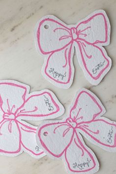 three tags with pink bows and happy birthday written on them