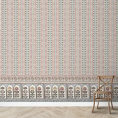 an empty chair sitting in front of a wallpapered with ornate designs on it