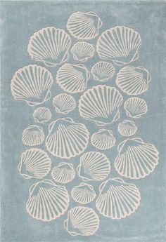 a blue and white rug with shells on it