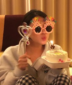 a woman wearing sunglasses and holding a cake