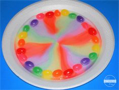 a white plate topped with gummy bears on top of a blue table